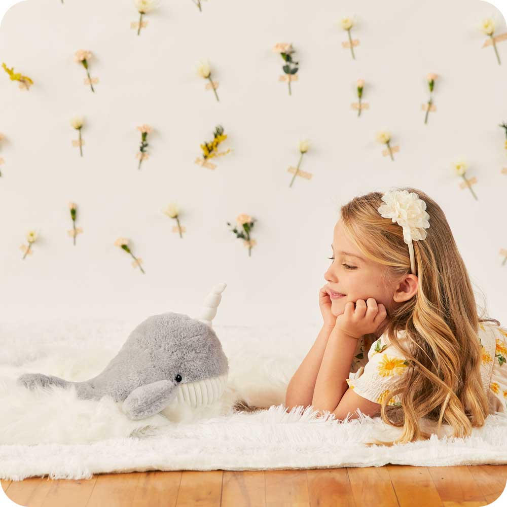 Image 100: Little girl smiling at Soft Warm Weighted Narwhal Plush Warmies