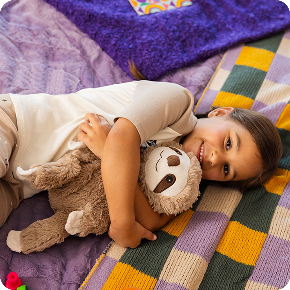 Image 98: girl cuddling sloth stuffed animal