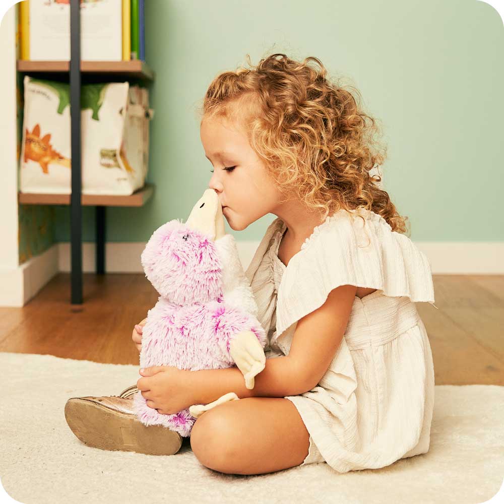 Image 106: Toddle sitting down holding a Soft Lavender Scented Platypus Warmies