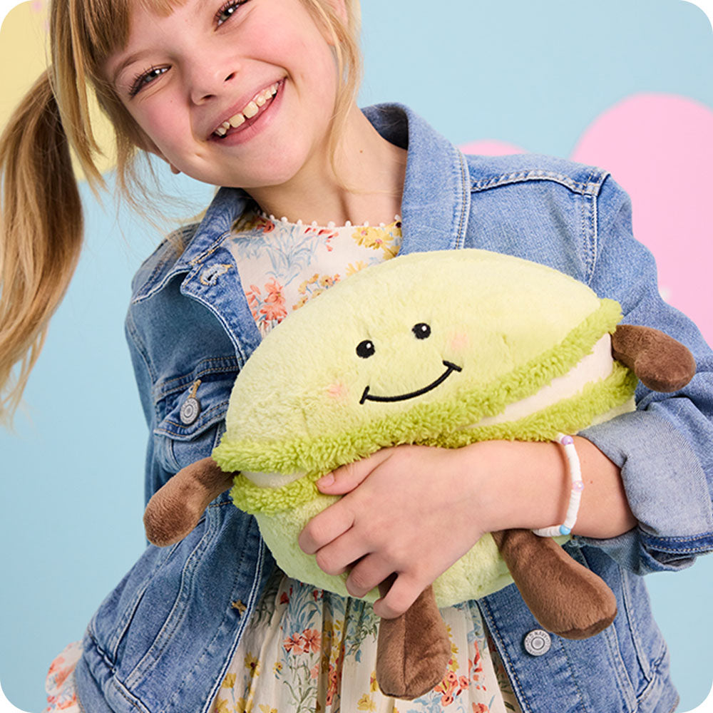 Image 98: girl holding macaron stuffed animal warmies