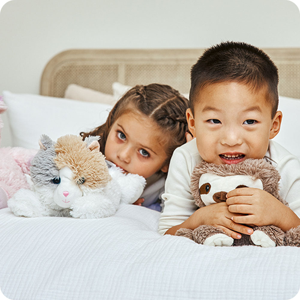 Image 101: kids cuddling calico cat warmies lifestyle