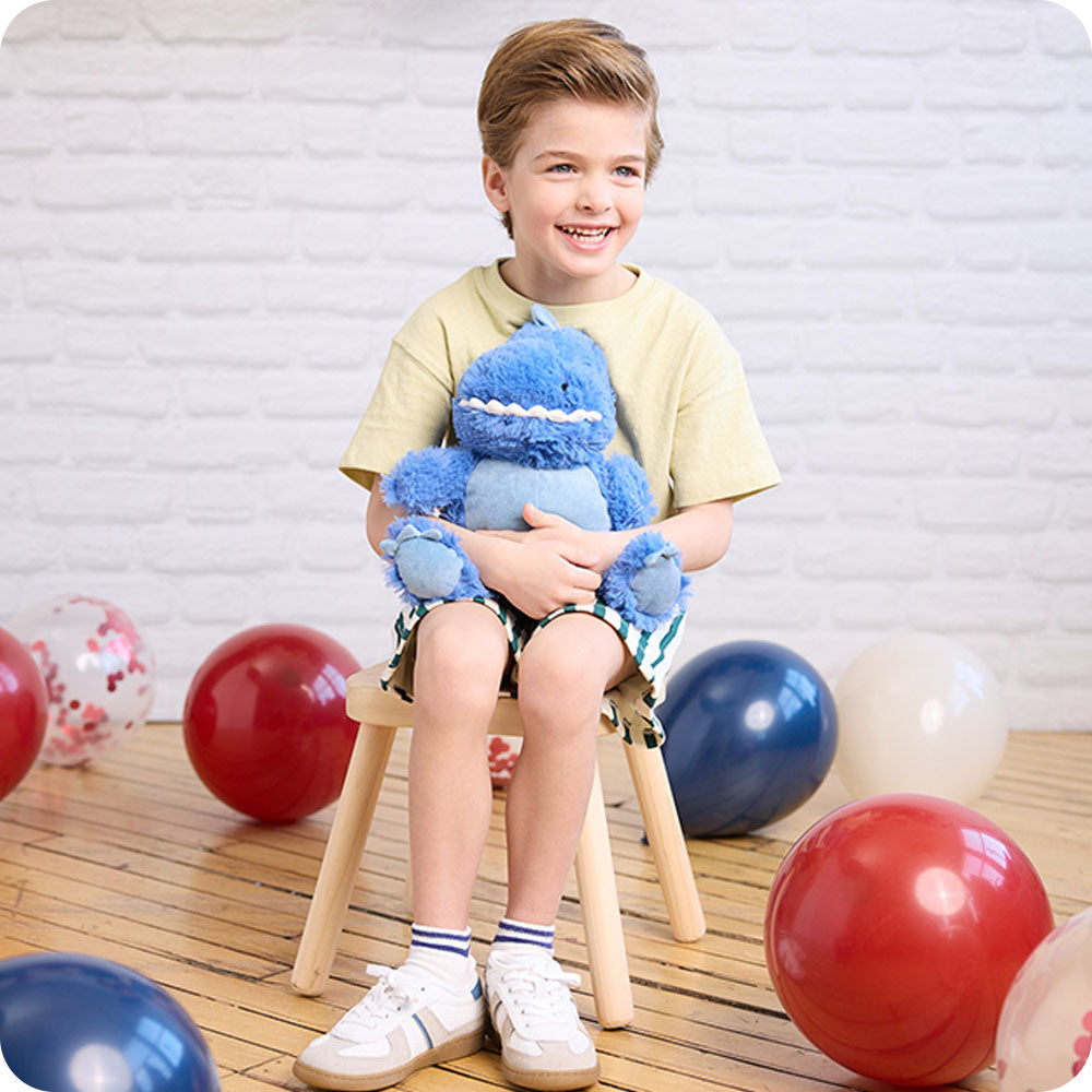 Image 102: boy hugging dinosaur stuffed animal