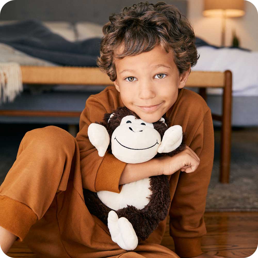 Image 99: Boy hugging Cute Weighted Lavender Scented Monkey Stuffed Animal Heating Pad Warmies